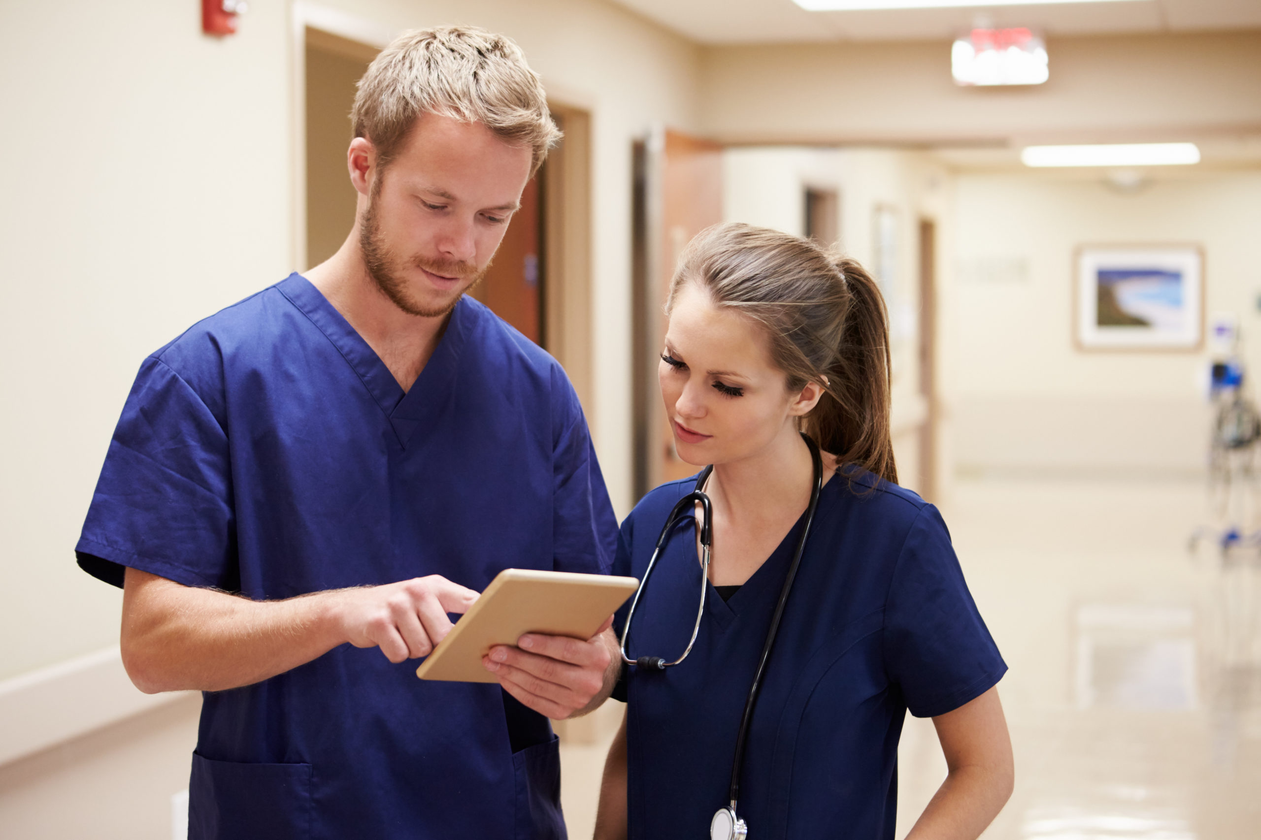 Male and female nurse looking at tablet