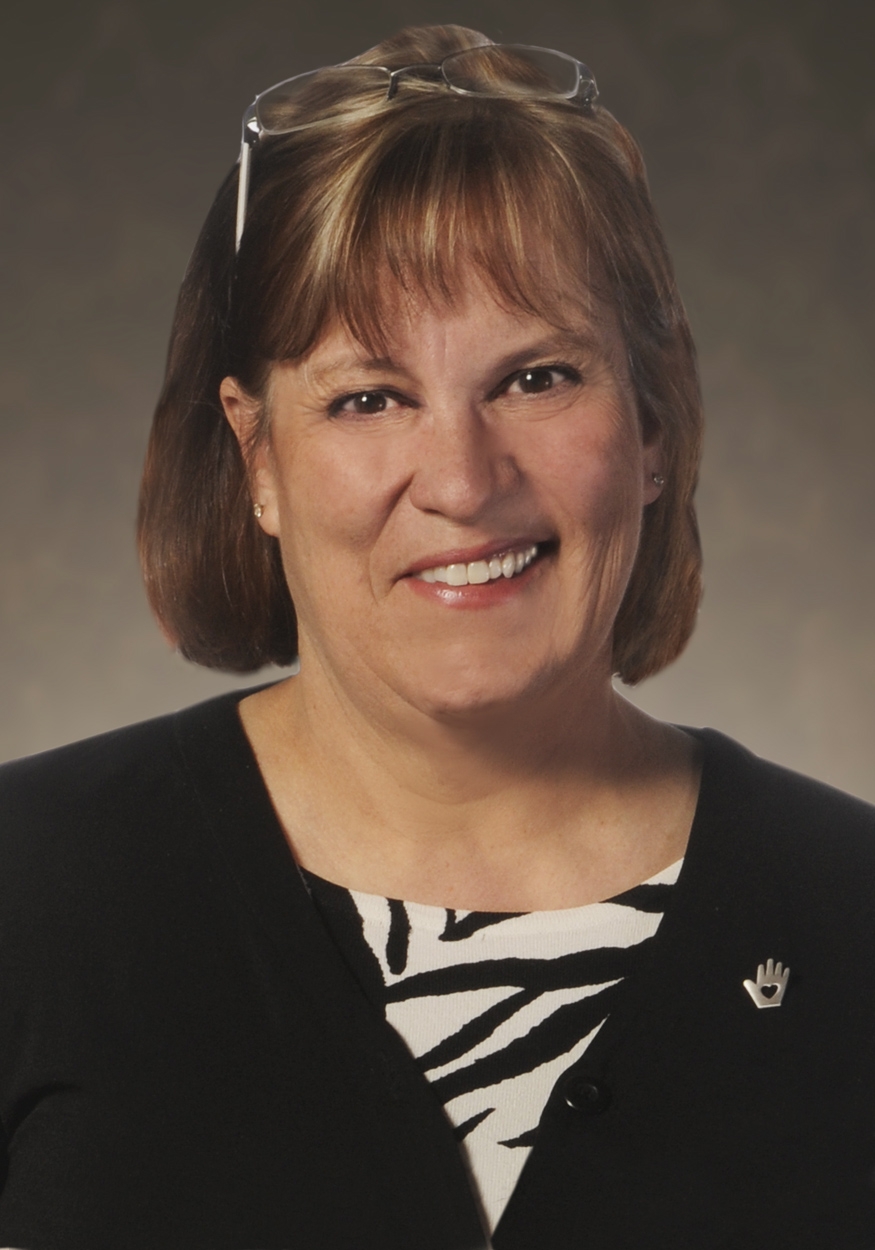 Woman wearing black and white top. Headshot of Dr. Laurel Benson.