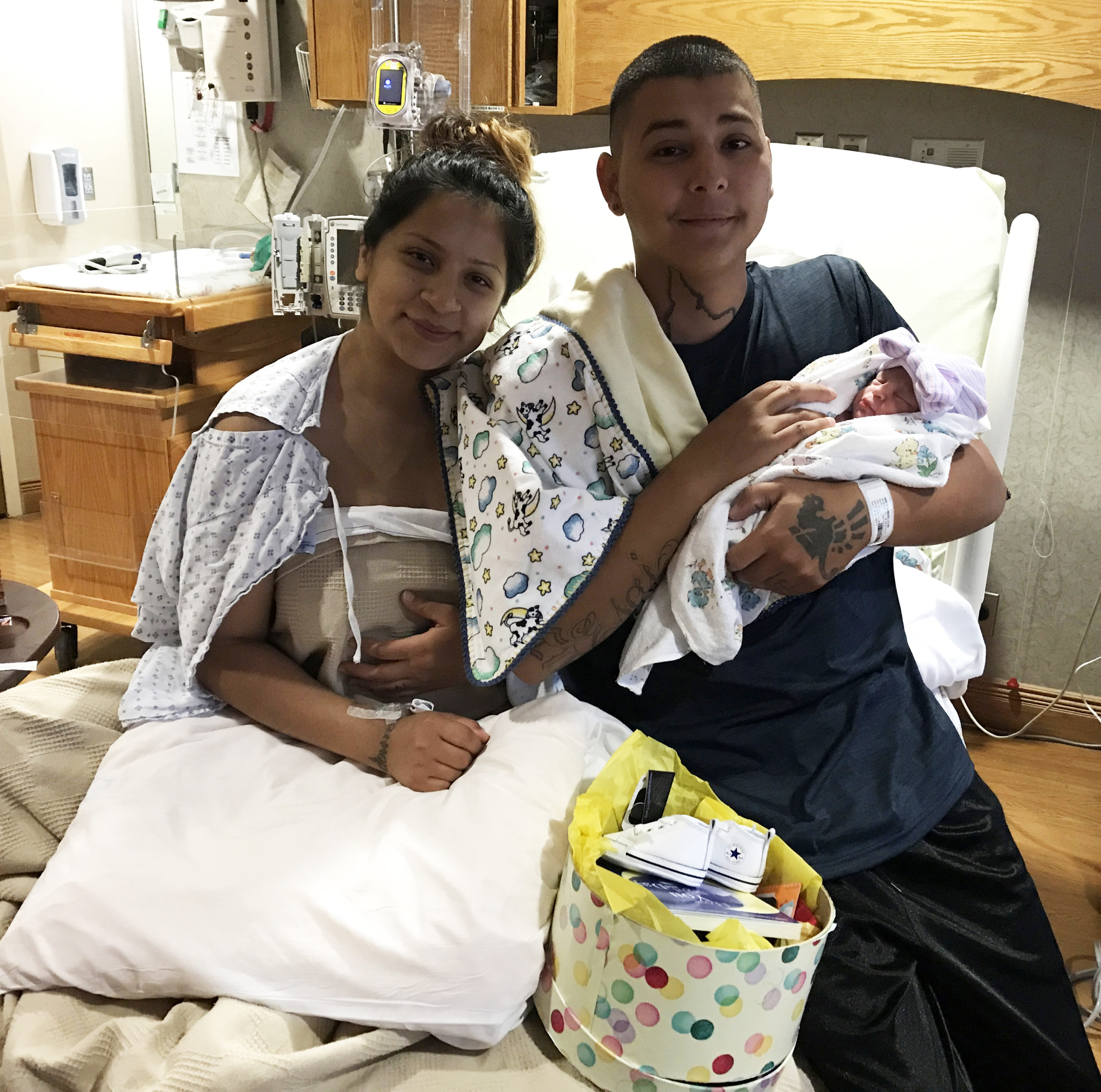 Mom and dad with newborn baby in hospital bed