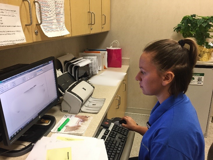 Female hospital intern sitting at computer