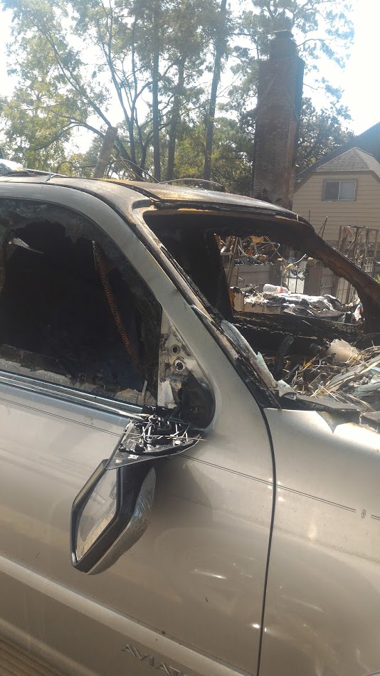 Car with missing windows filled with debris after hurricane