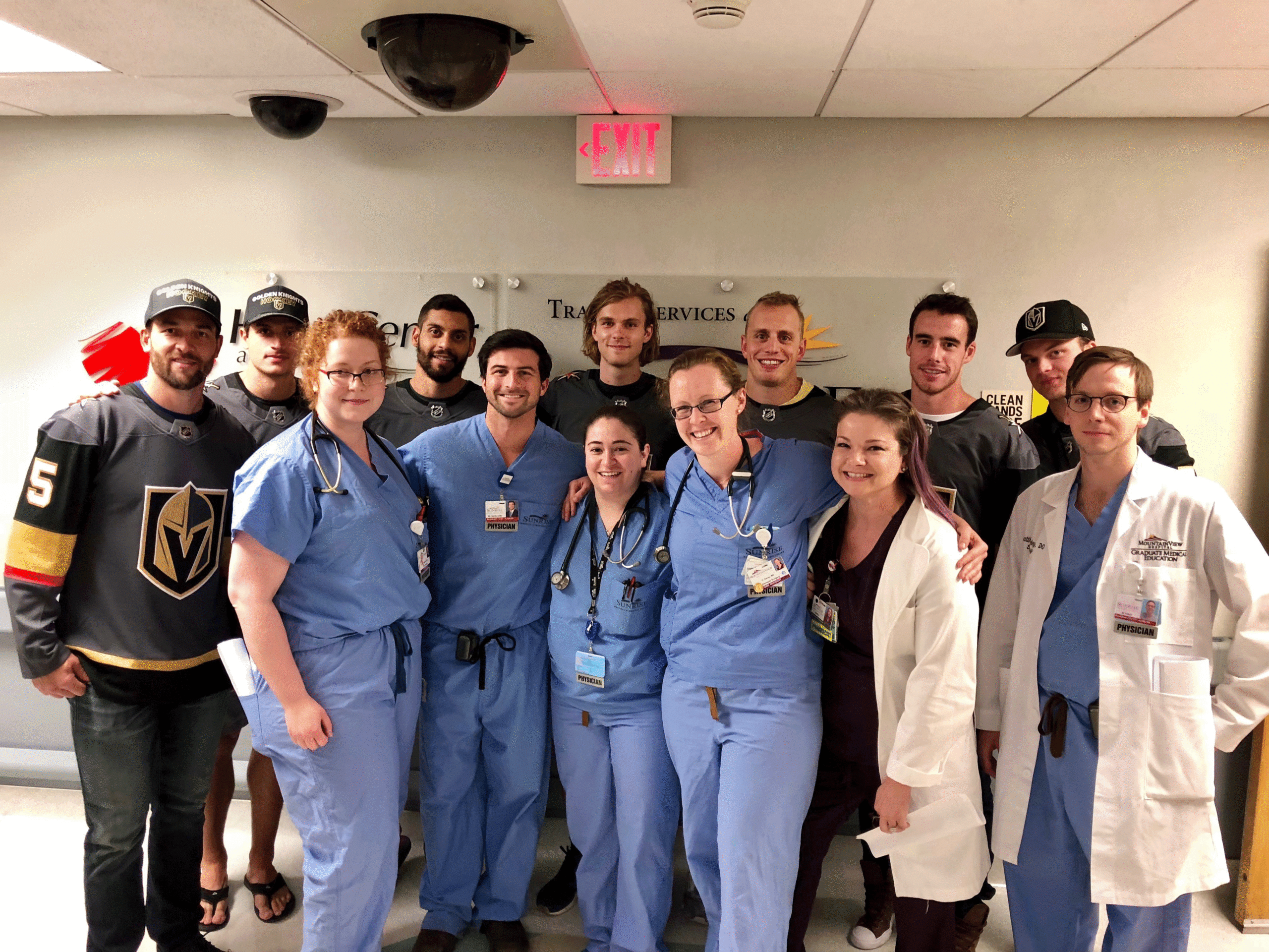 Hospital caregivers posing with members of the Vegas Golden Knights hockey team