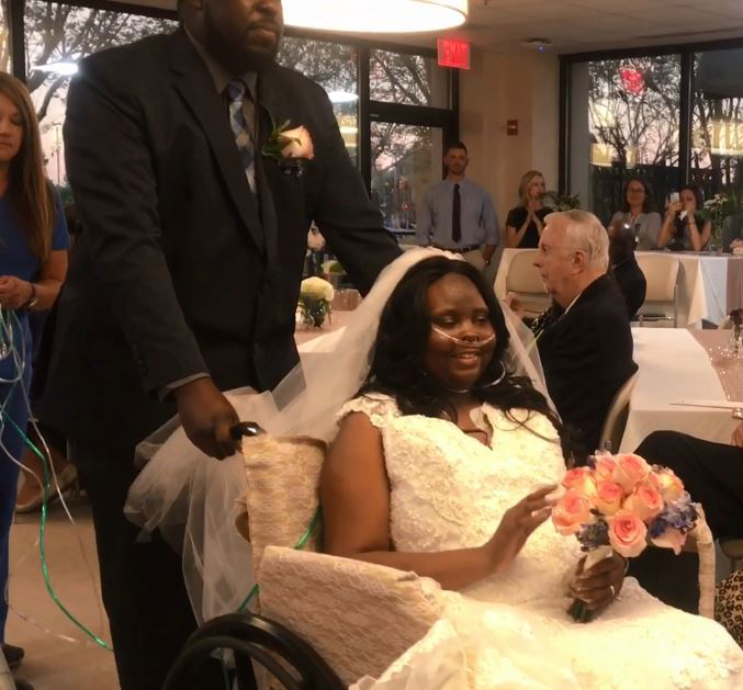 Groom pushing bride in wheelchair