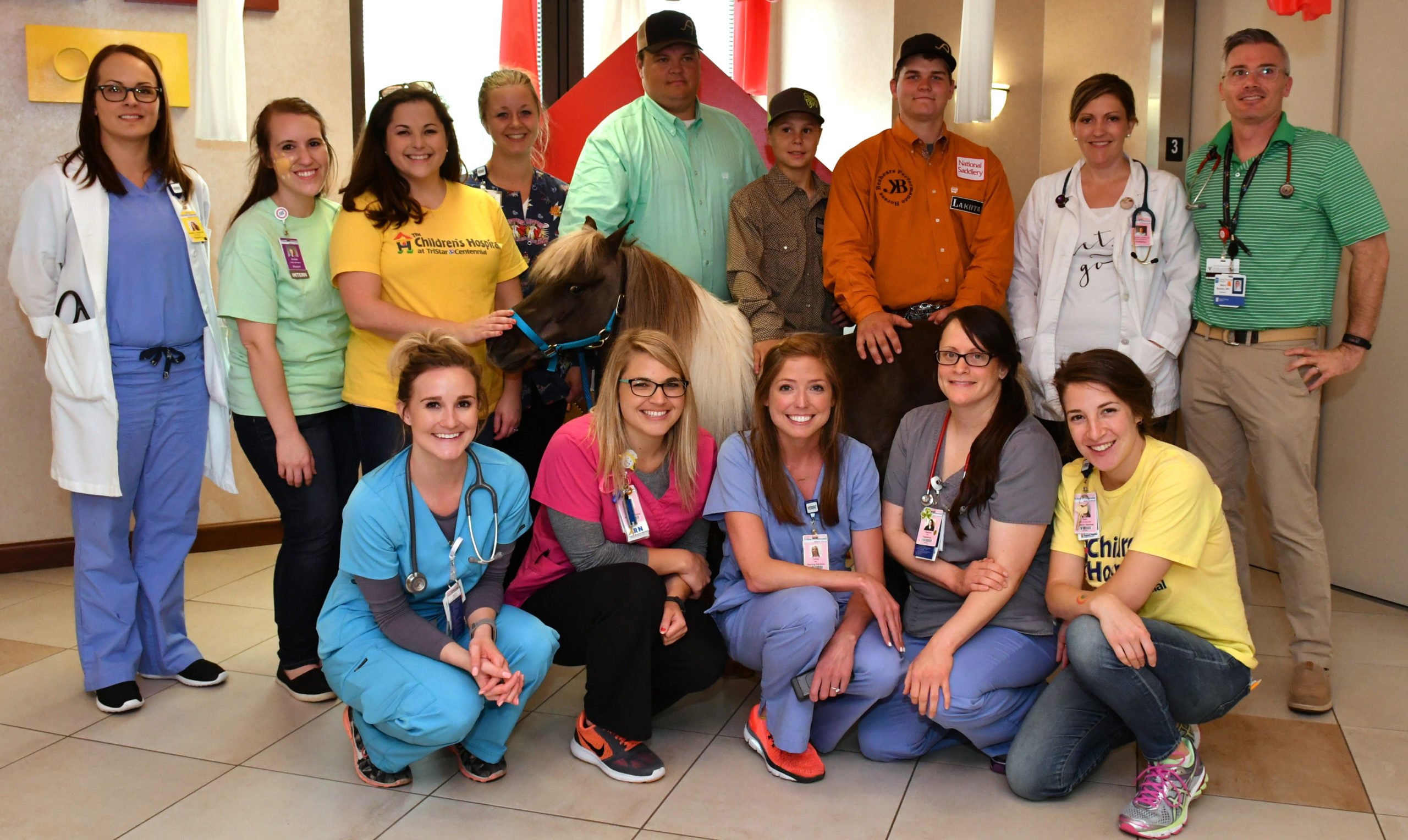 Group of hospital caregivers posing with a pony