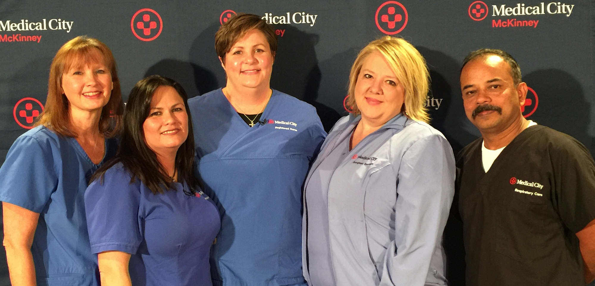 Five hospital caregivers in scrubs
