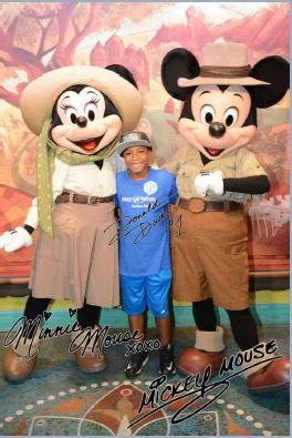 Boy posing with Mickey and Minnie Mouse