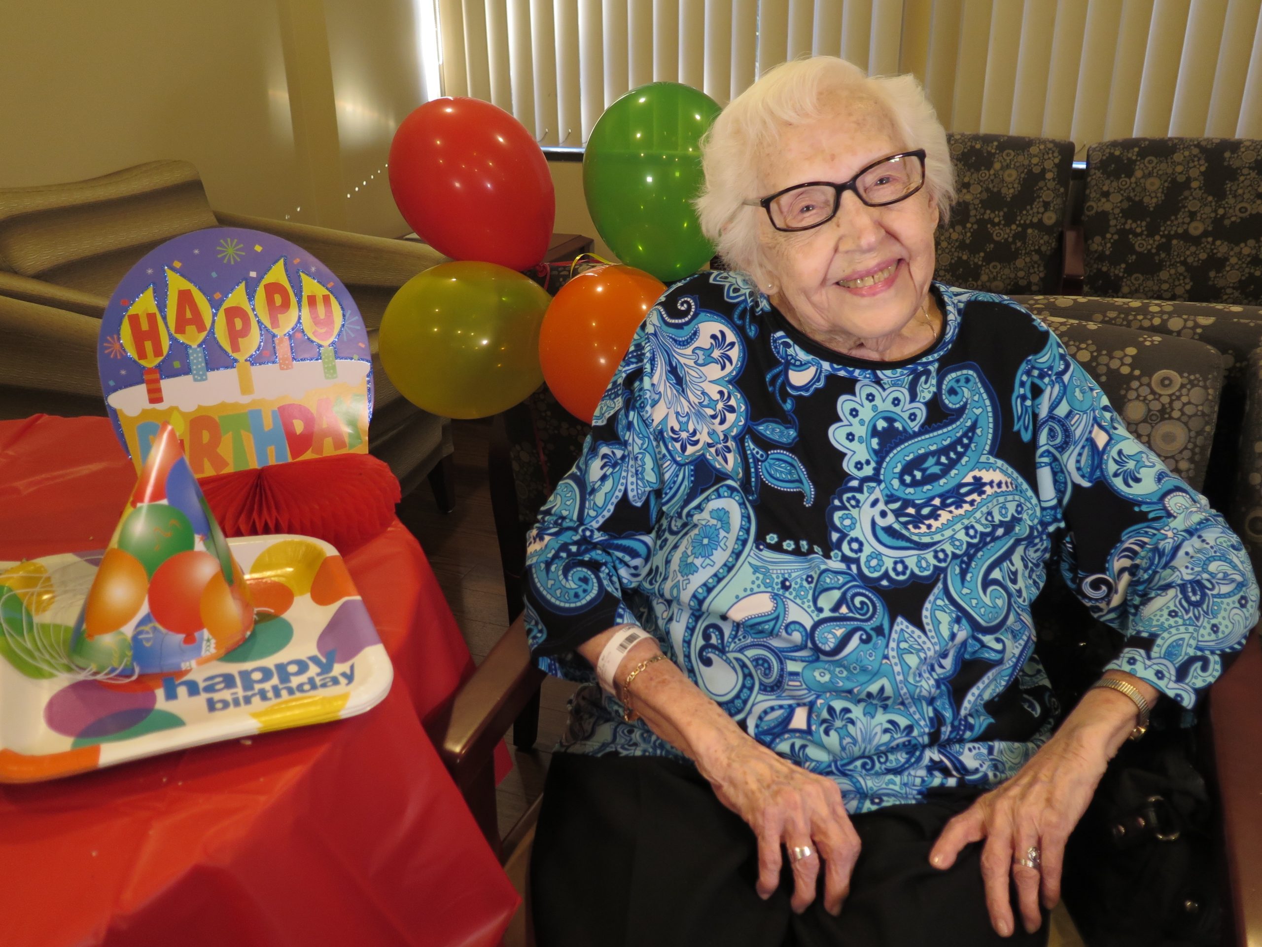 99-year-old patient posing with birthday decorations