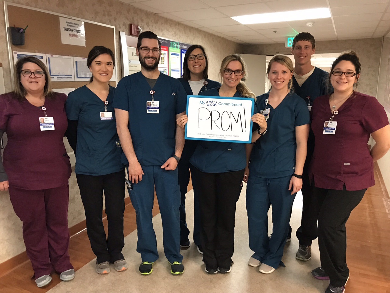 A group of nurses holding whiteboard that says "prom"
