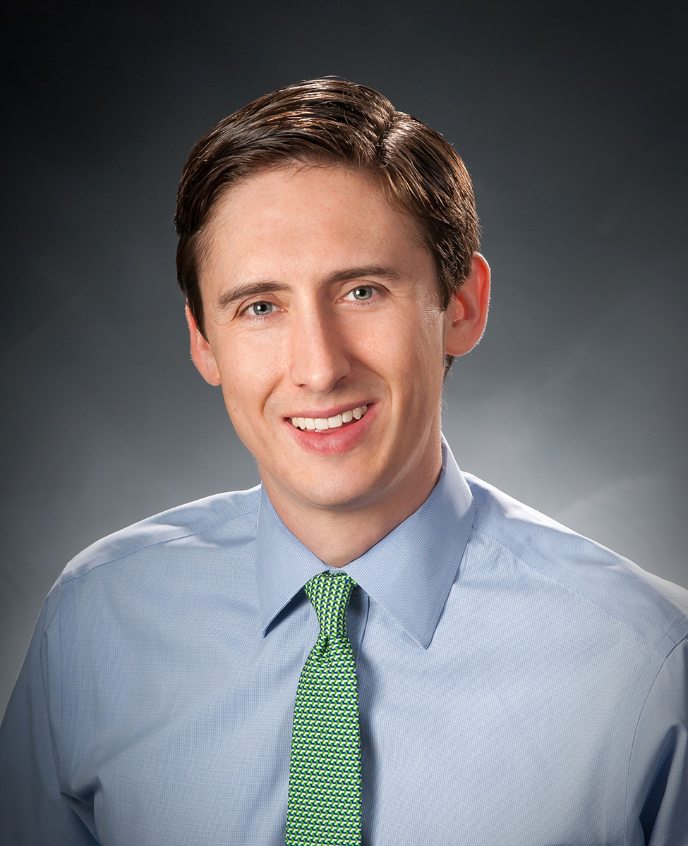 Man wearing blue button down shirt and green tie