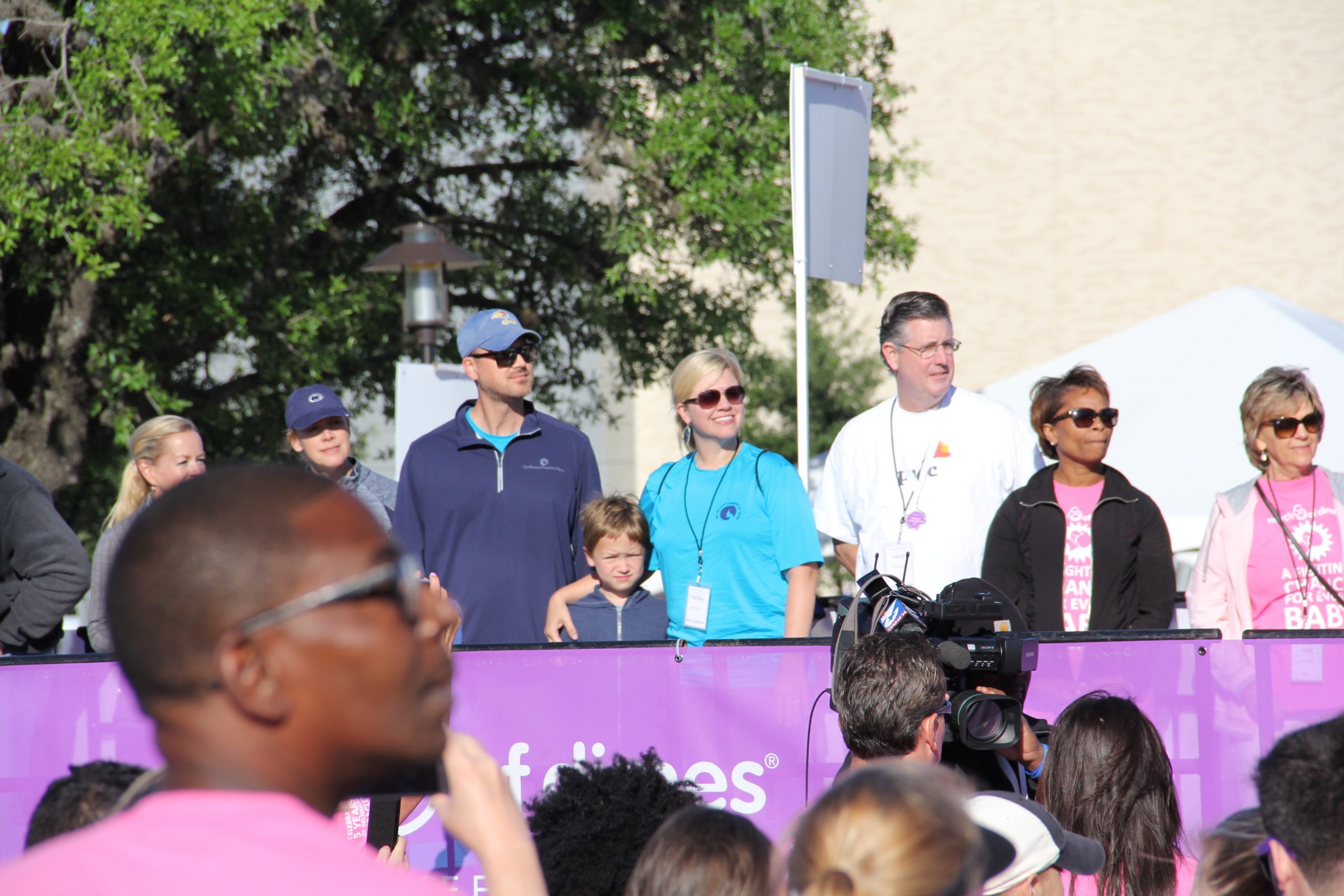 A group of people on stage before charity walk event