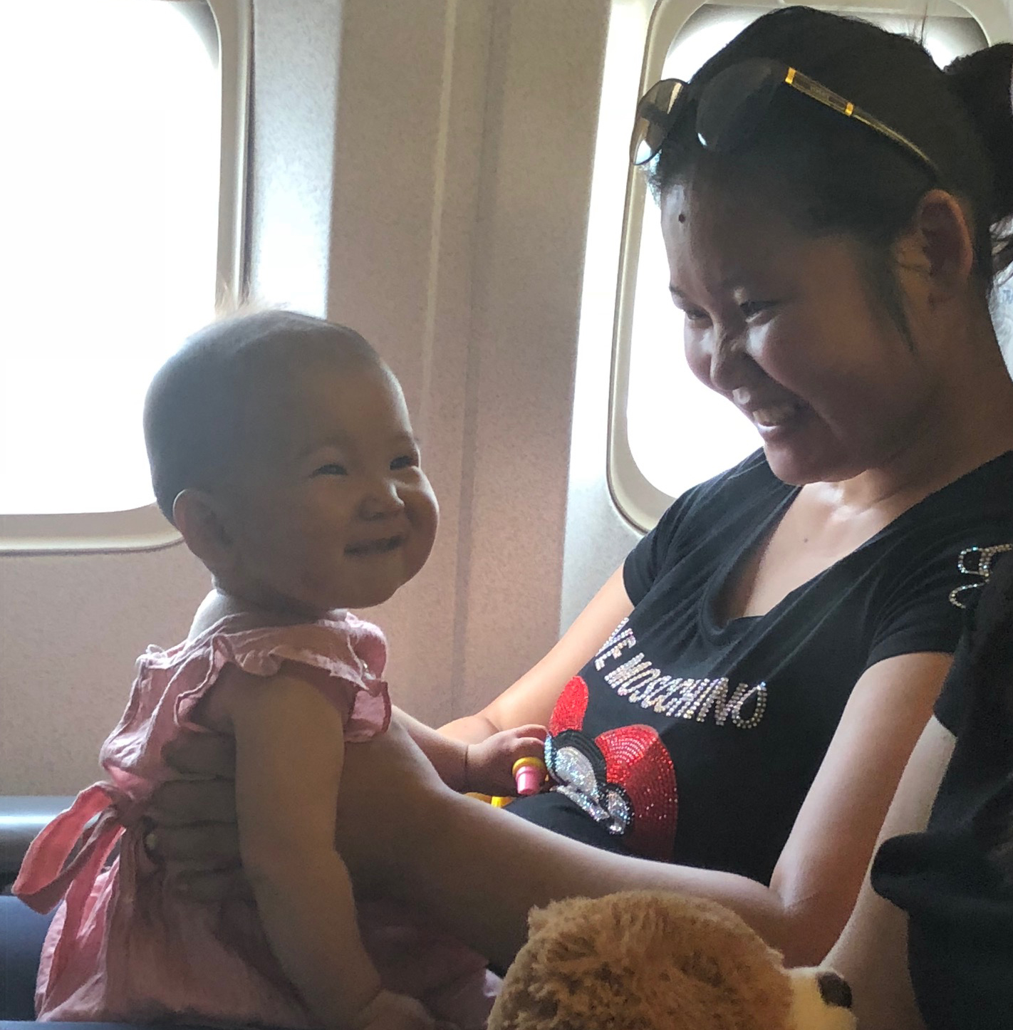 Woman holding baby in her lap in airplane seat