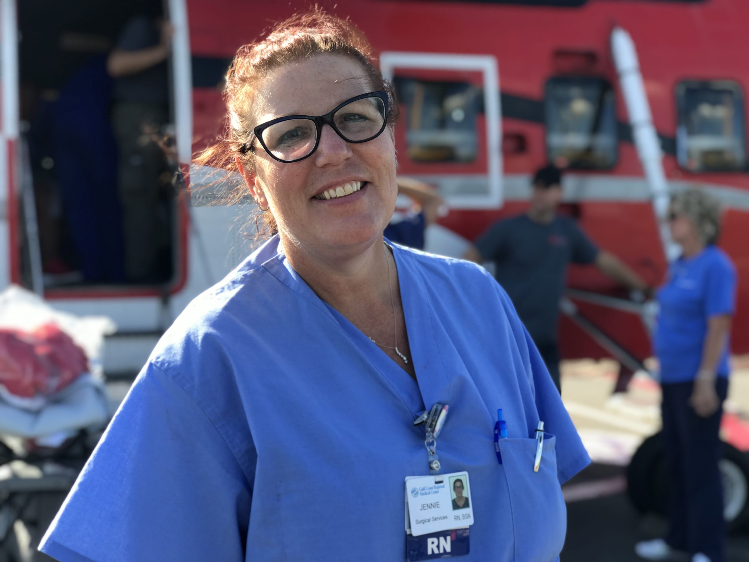 Smiling female nurse in blue scrubs