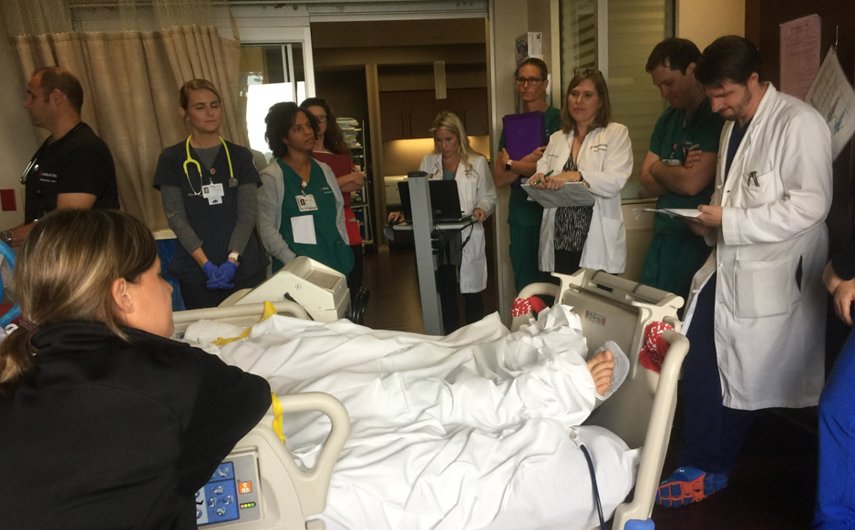 Hospital care team surrounding a patient's bed