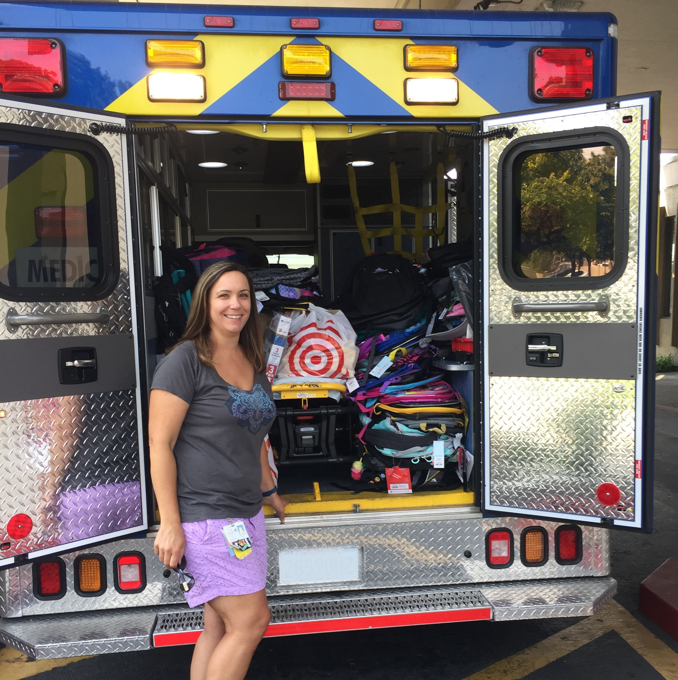 Woman standing in front of ambulance filled with donations