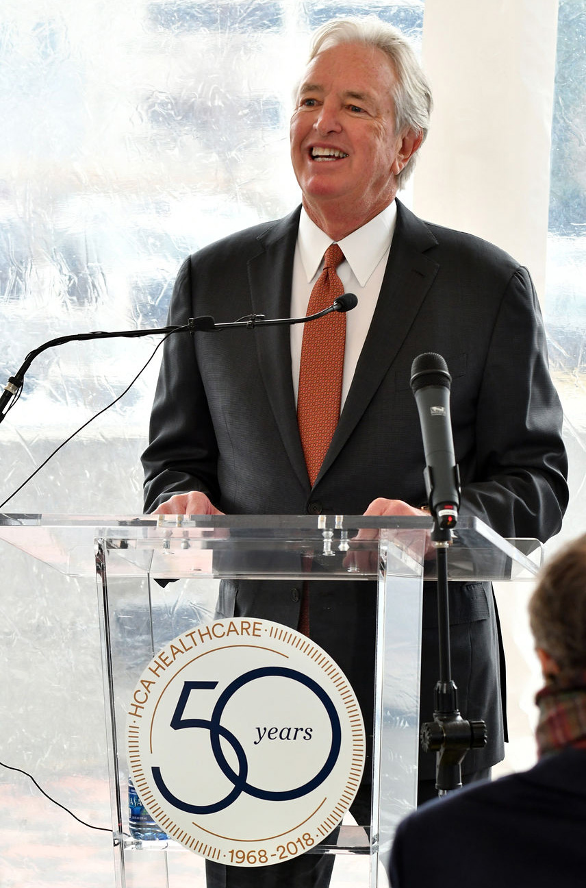 Man wearing suit and tie standing at a podium