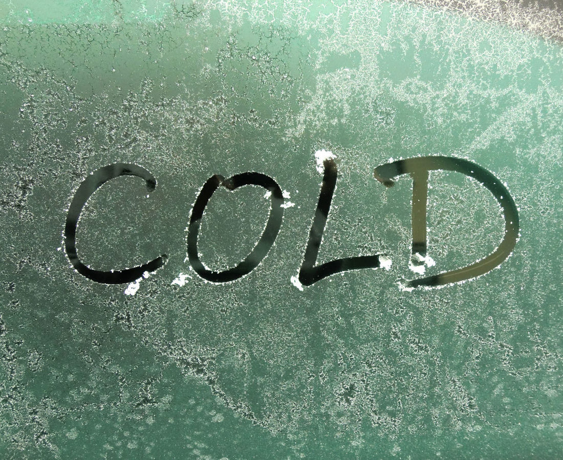 The word "cold" written on a frosted window
