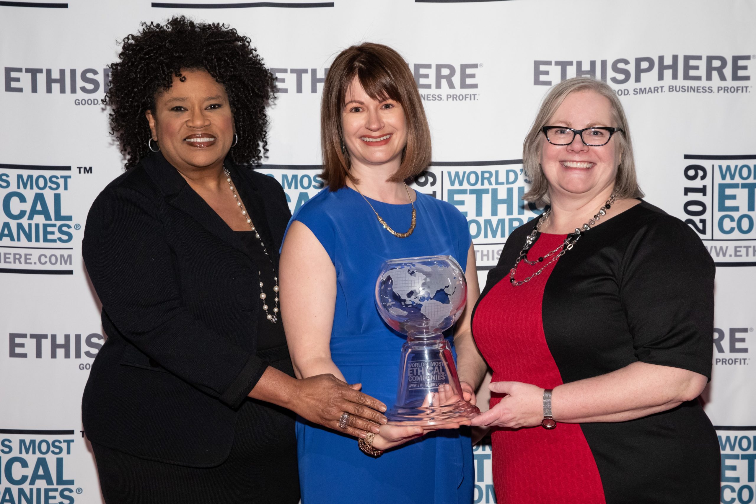 Three women holding award
