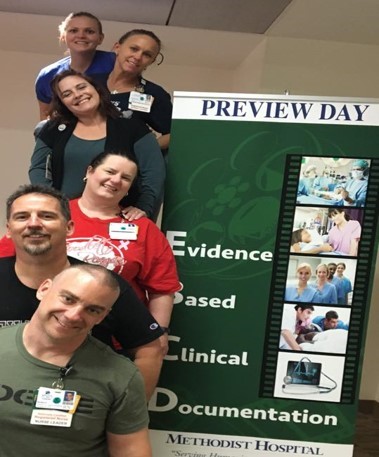 A group of nurses posing next to a sign that says Evidence Based Clinical Documentation Preview Day