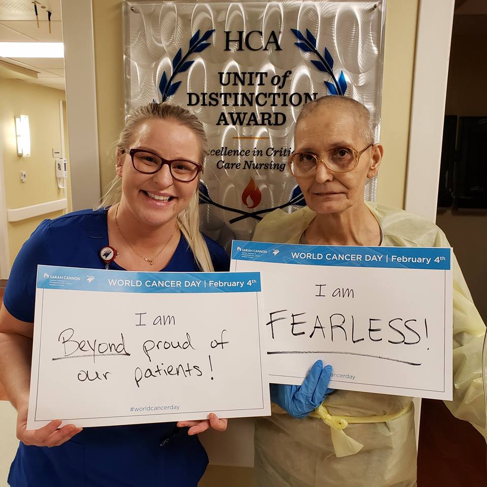 A nurse and cancer patient holding signs for World Cancer Day