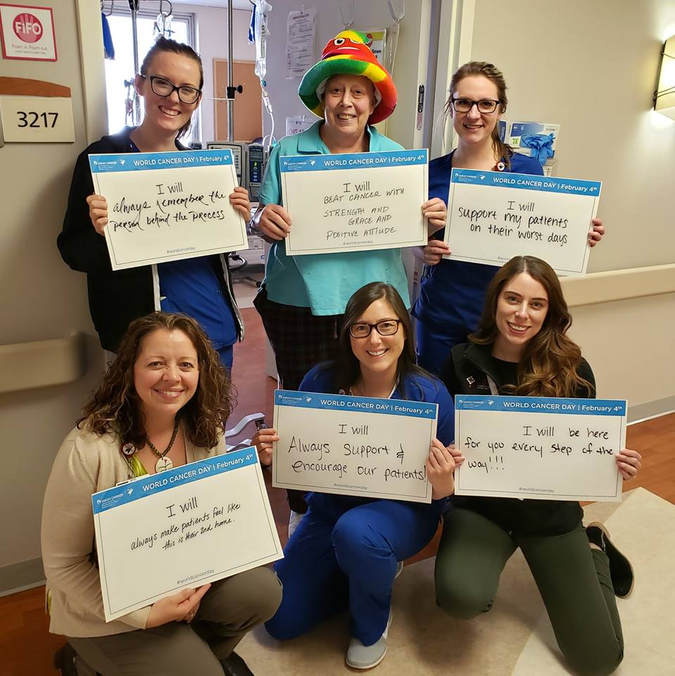 A group of nurses and cancer patient holding signs for World Cancer Day