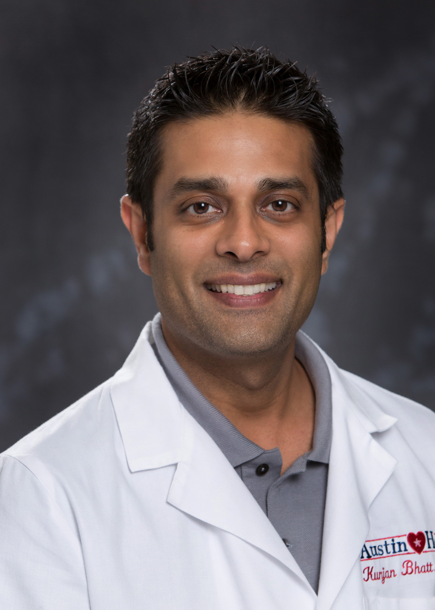 A male doctor in a white lab coat. Headshot of Dr. Kunjan Bhatt