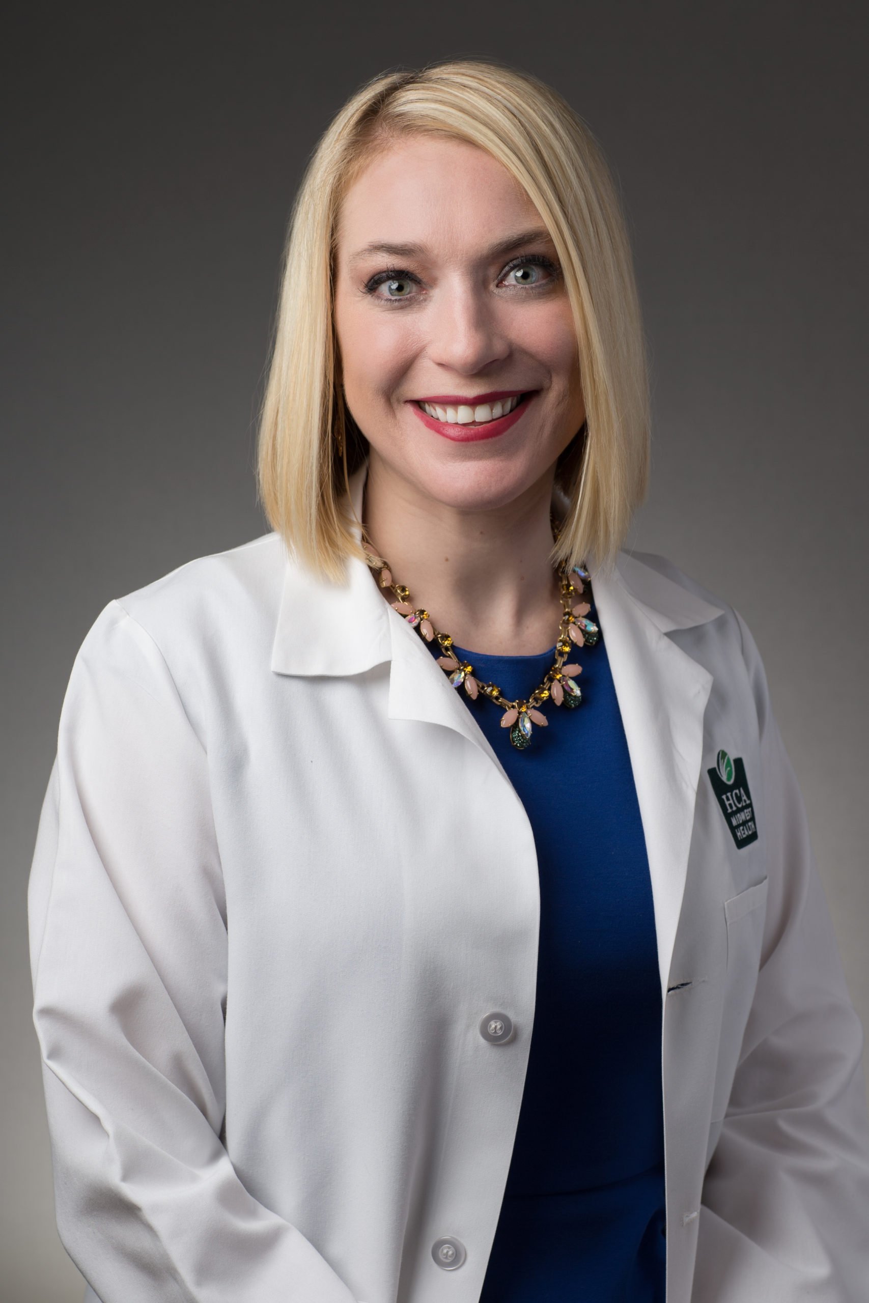 A female doctor in a white lab coat. Headshot of Dr. Stephanie Graff.