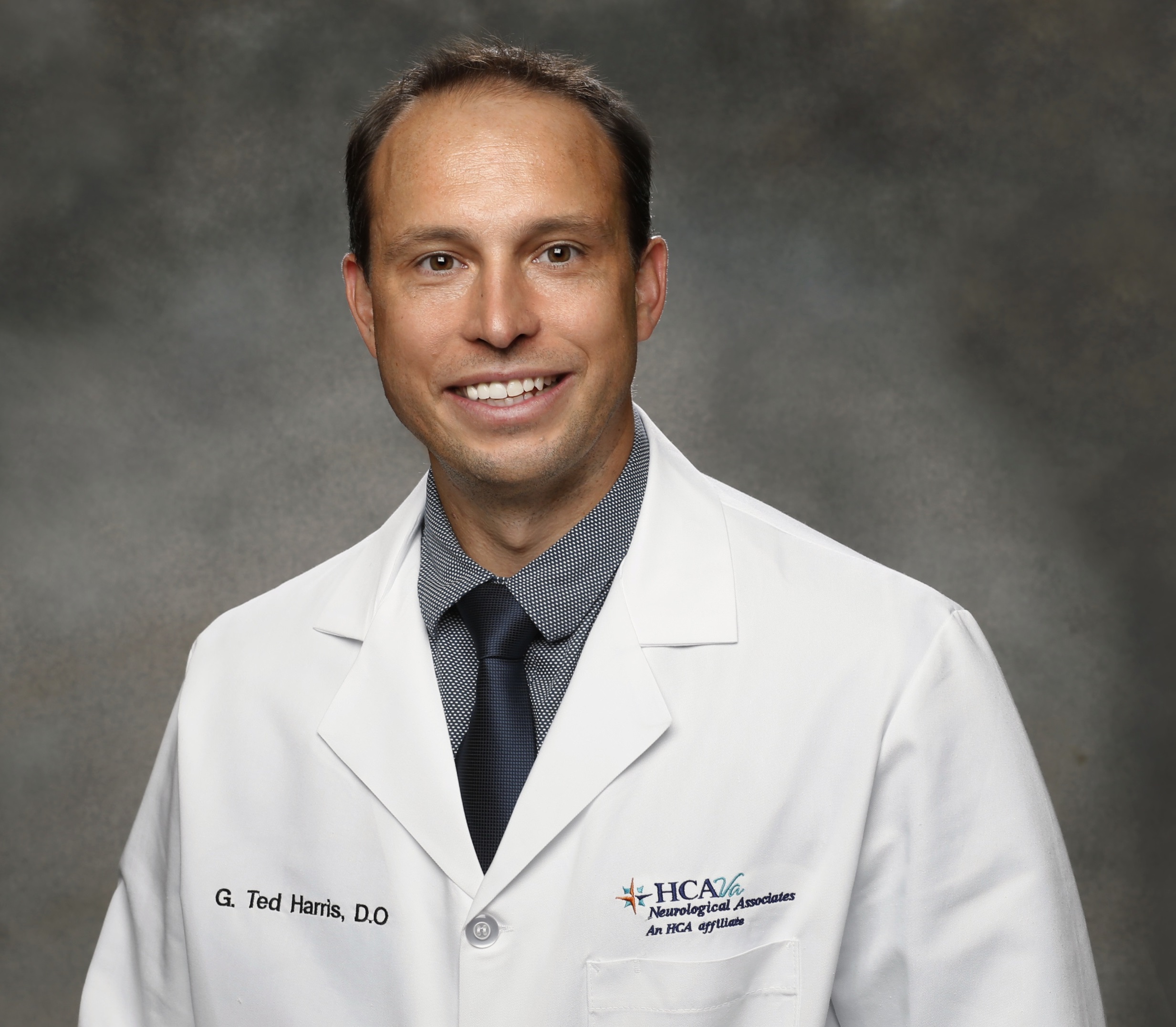 Man wearing a white lab coat. Headshot of Dr. Harris.
