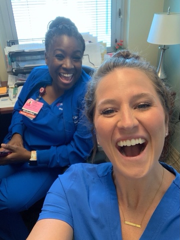 Two female nurses smile while taking a selfie