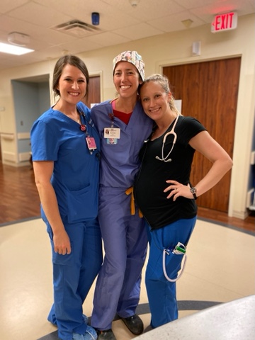 Three smiling nurses in scrubs