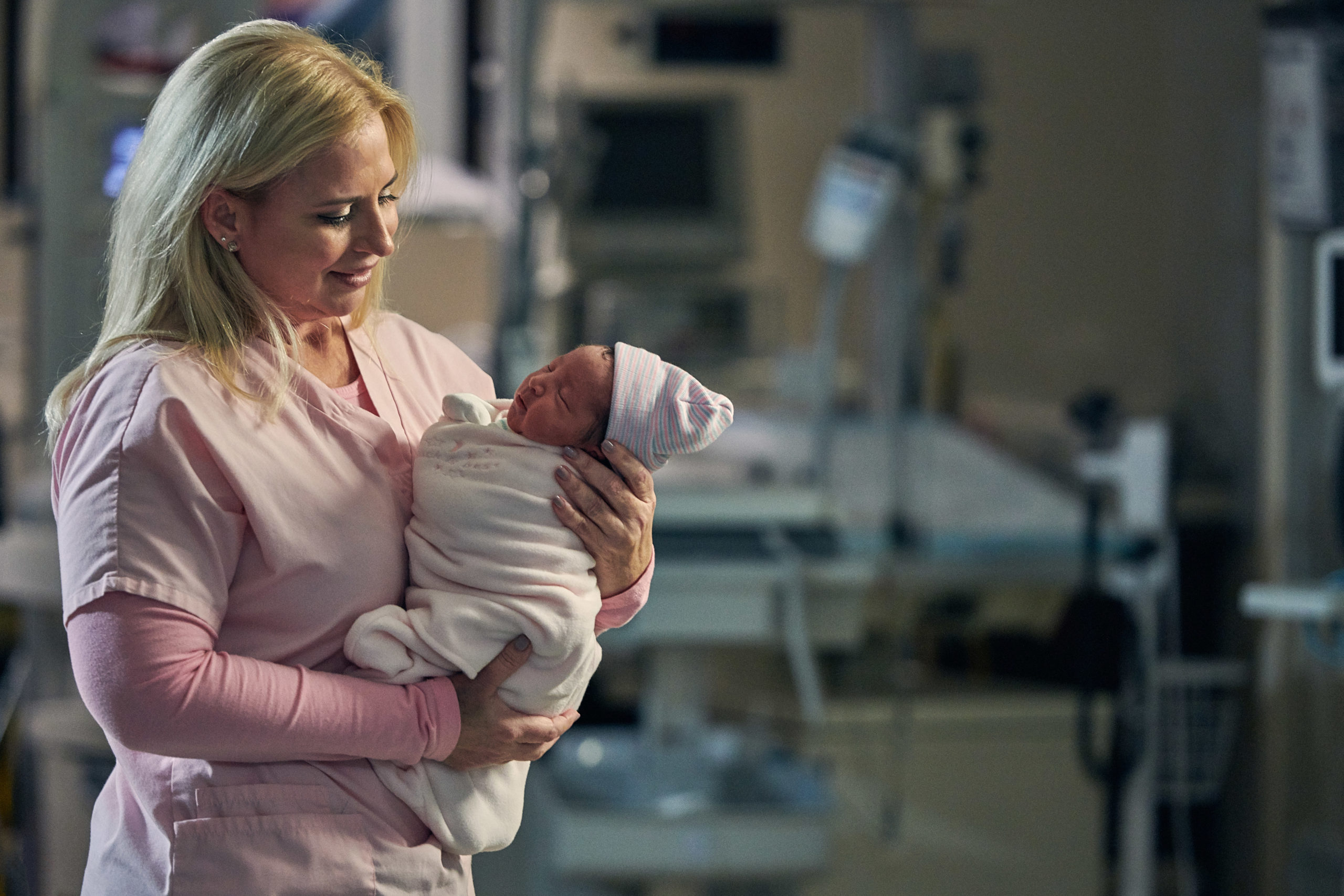 A female nurse holds a newborn baby