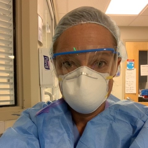 Closeup of Tammy Stimmerman wearing protective hair mask, goggles, face mask and scrubs