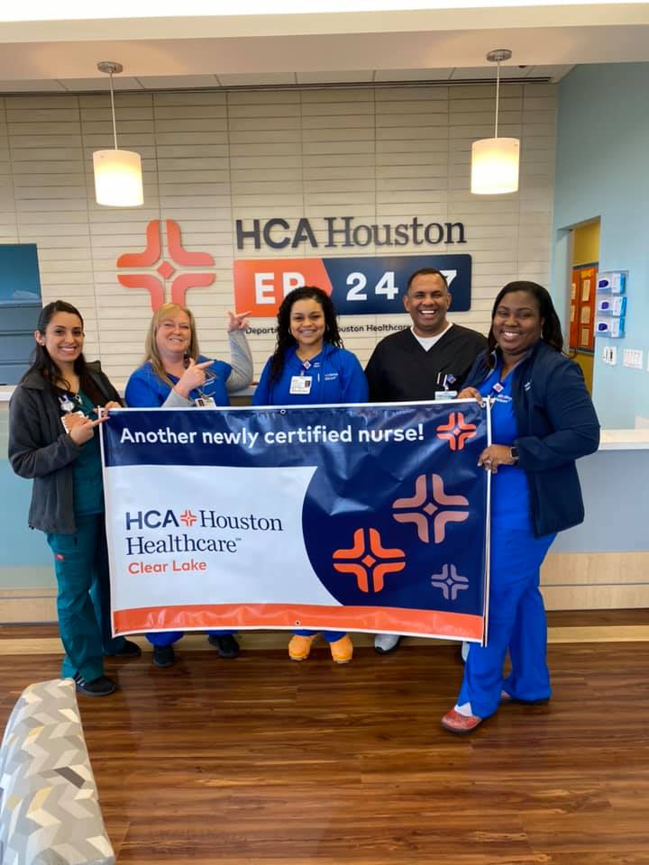 A group of nurses at HCA Houston Healthcare Clear Lake hold a sign celebrating a newly certified nurse 