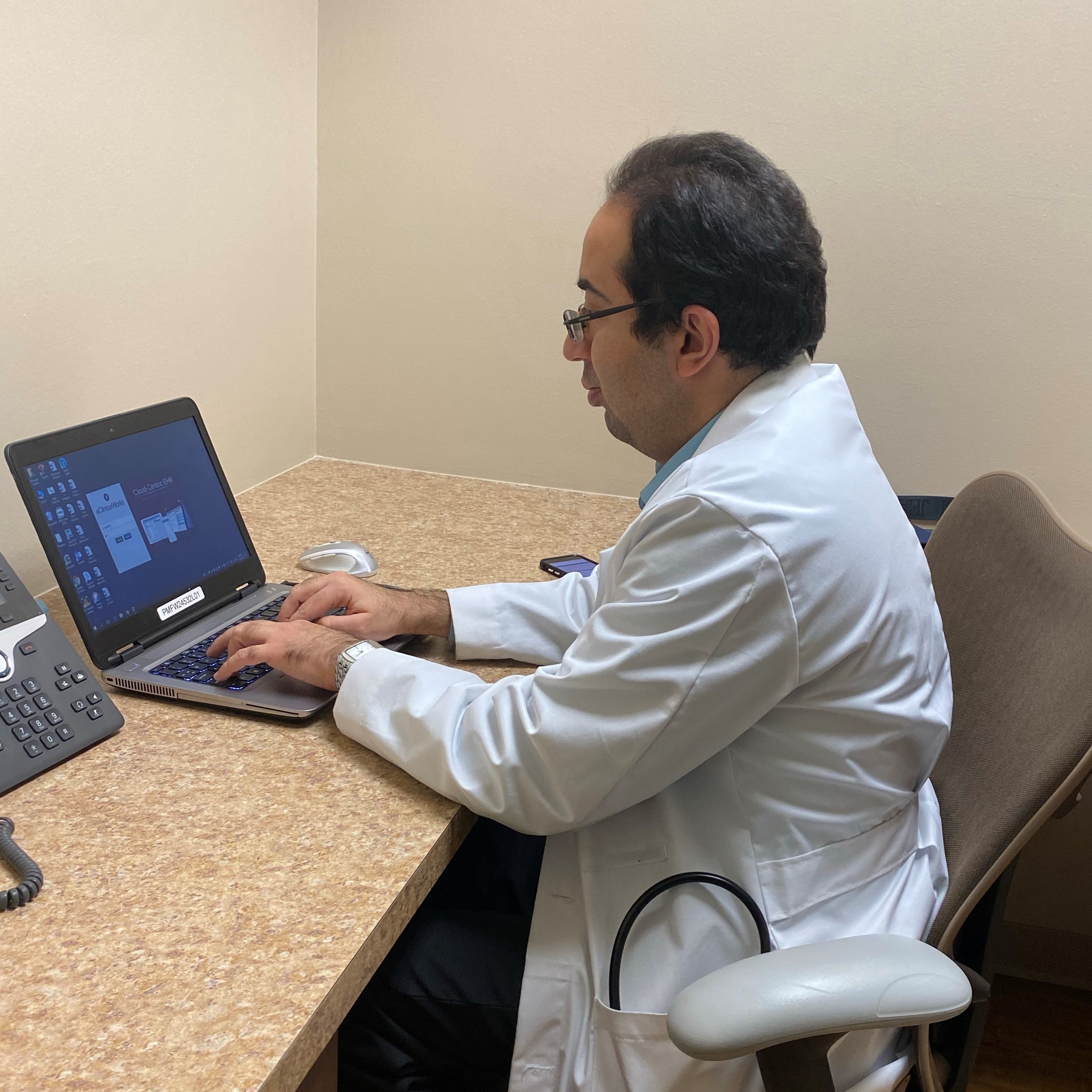 Dr. Farshad Bozorgnia works on his laptop