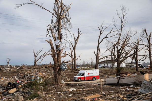 An American Red Cross van parked in the middle of a tornado-damaged neighborhood