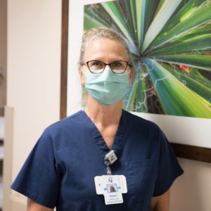 Woman wearing a face mask and navy blue scrubs