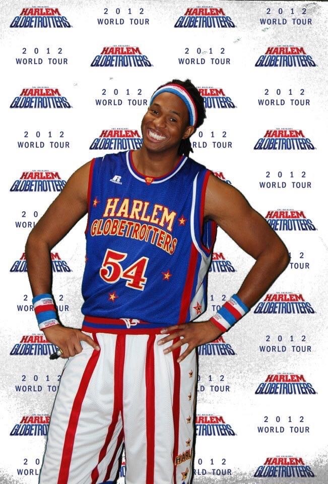Jay Middleton standing in Harlem Globetrotters uniform in front of wall that says "Harlem Globetrotters 2012 World Tour" 