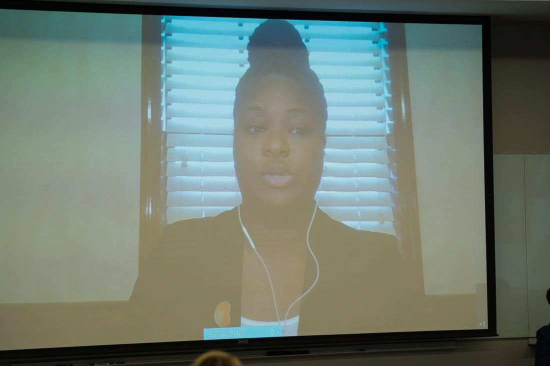 Large screen showing a woman participating in a meeting via video call. 