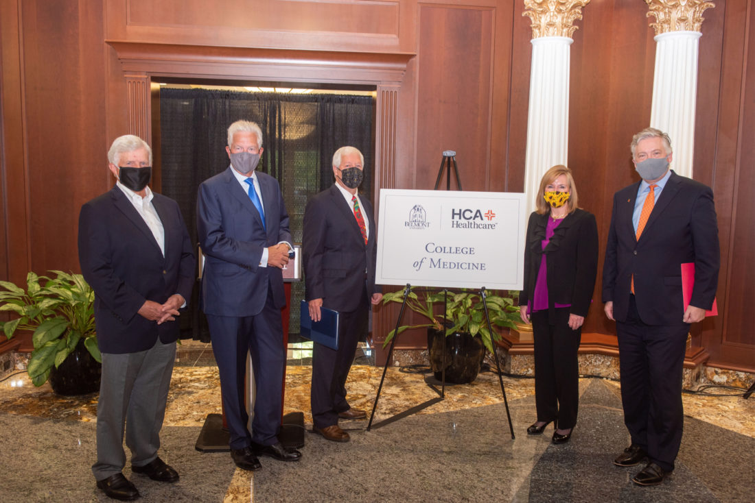 Five people wearing suits and face masks standing with a sign that says College of Medicine with the Belmont University and HCA Healthcare logos