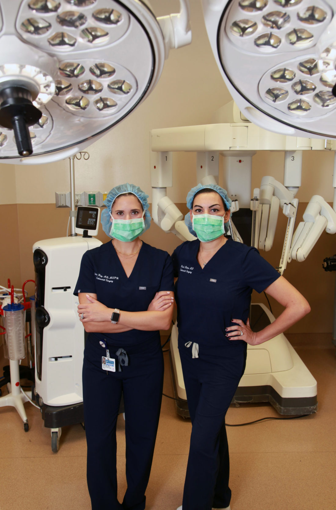 Two female surgeons wearing scrubs and face masks in the operating room