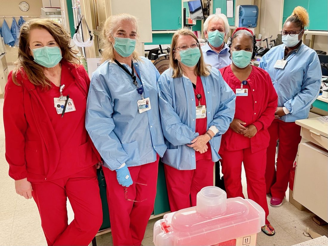 Group of lab technicians wearing scrubs and face masks. 