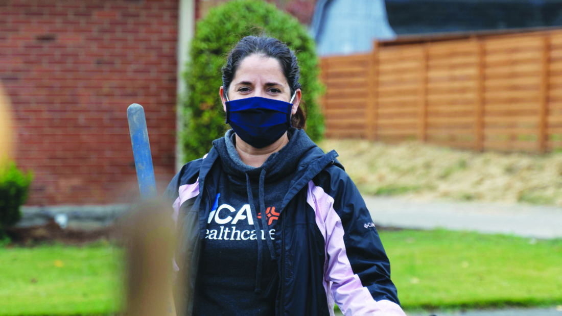 Woman wearing a face mask and jacket outside. 