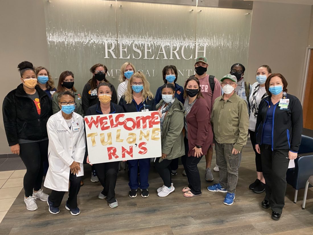 Group of nurses wearing face masks posing with sign that says Welcome Tulane RNs. 