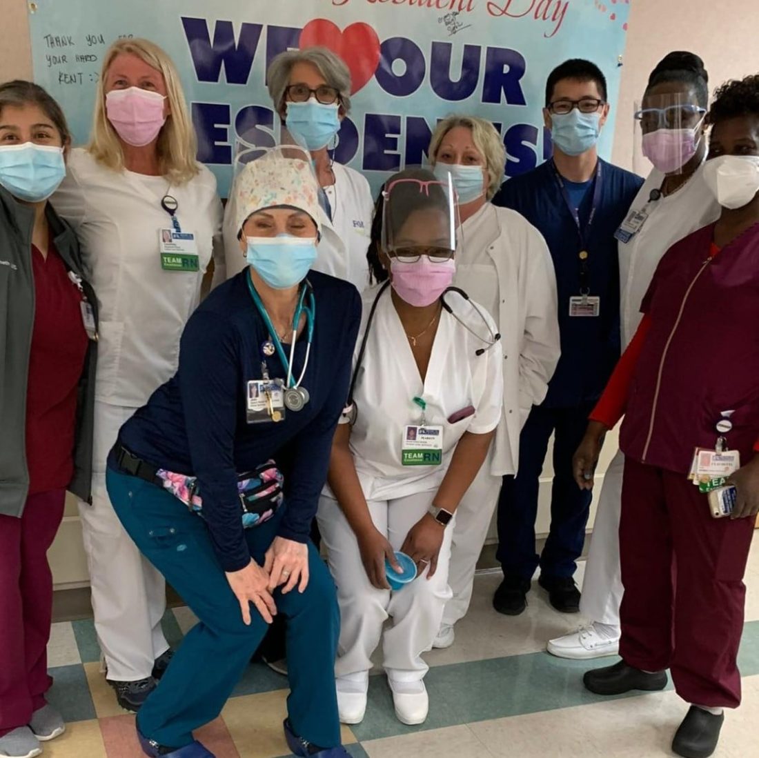 Group of resident physicians wearing face masks and scrubs. 