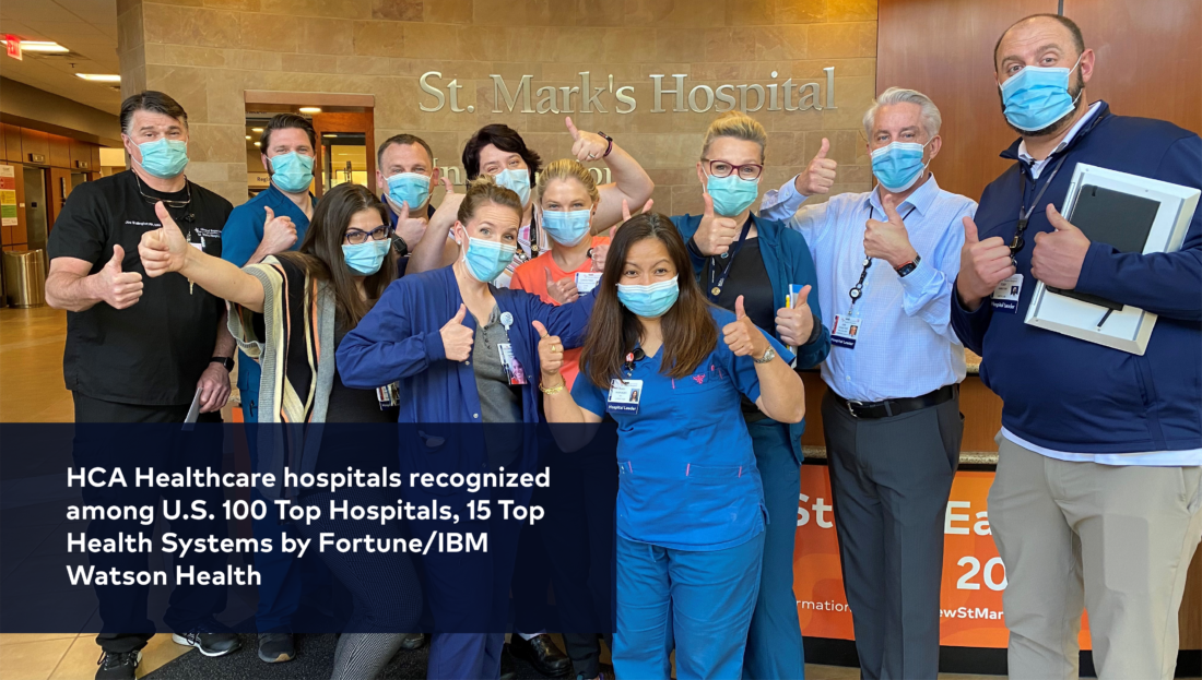 Group of hospital workers wearing face masks and giving thumbs up. 