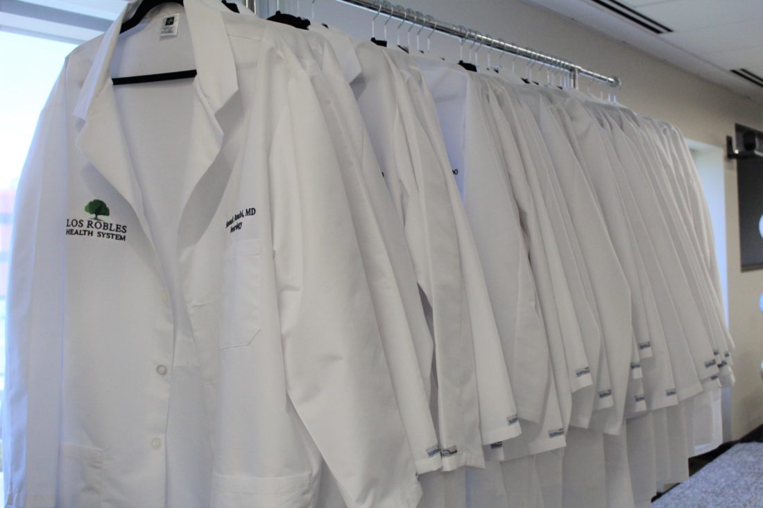 A rack of white physician coats.