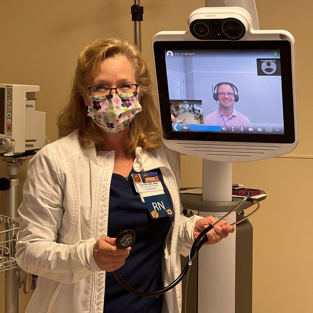 Nurse wearing a mask next to telehealth technology. 