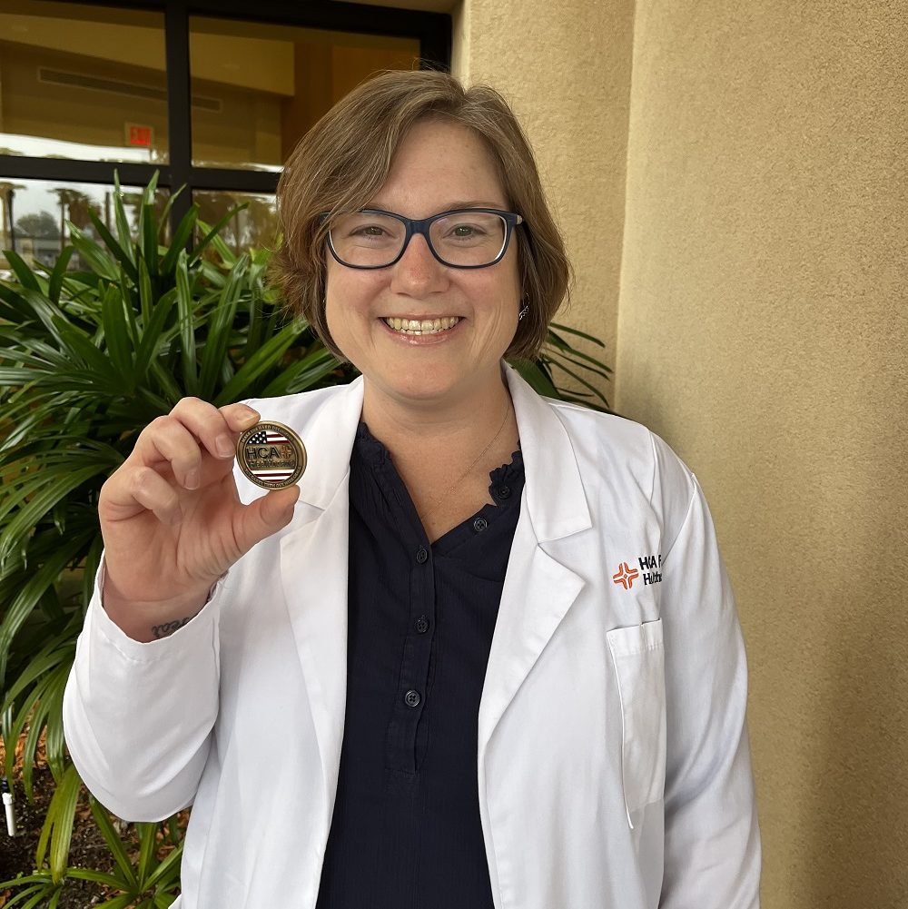 Jennifer Deleon holding an HCA Healthcare Challenge Coin