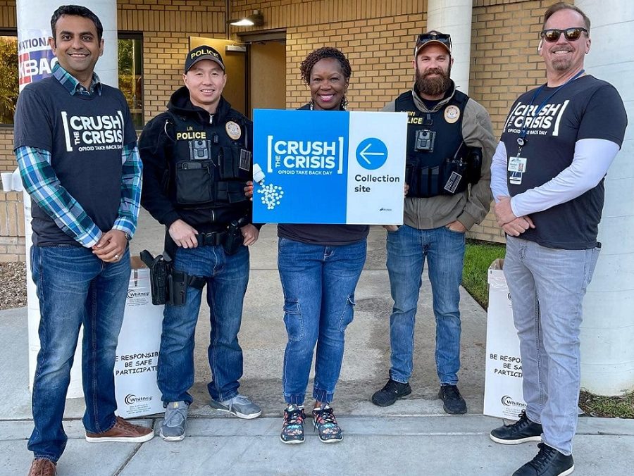 HCA Healthcare colleagues at Riverside Community Hospital and local law enforcement smile for picture with Crush the Crisis collection site sign. 