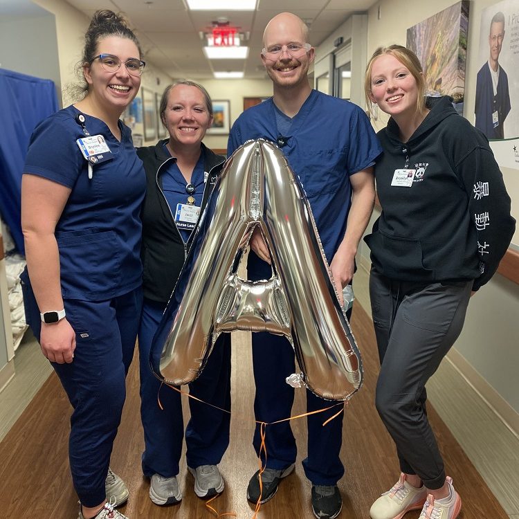 HCA Healthcare colleagues at Lakeview Hospital smile while holding a balloon in the shape on an A. 