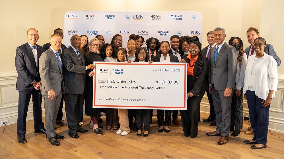 HCA Healthcare colleagues and Fisk University staff and students smiling for picture with a large check. 